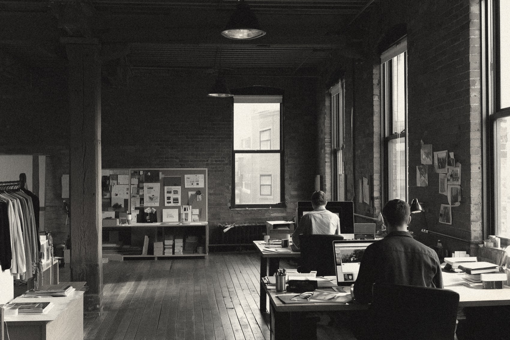 Interior of a restored 1930s brick suite — exposed brick, original wood floors, tall windows